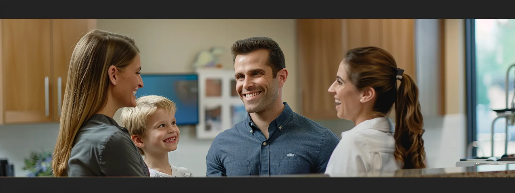 a smiling family at the olathe dentist office, discussing insurance and payment options with the friendly staff.